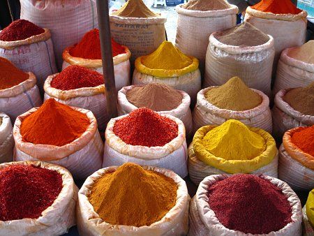 Sachets de différentes épices colorées dans des sacs en toile, parfaits pour la cuisine et les recettes aromatiques.