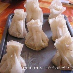 Choux prêts à cuire, garnis d'ingrédients, disposés sur une plaque de cuisson pour réaliser des éclairs ou profiteroles maison.