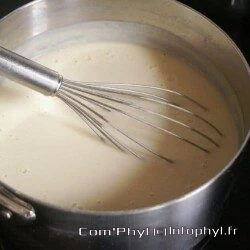 Sauce béchamel crémeuse dans une casserole, idéale pour les gratins et lasagnes, préparée avec du beurre, de la farine et du lait pour une texture lisse et onctueuse.