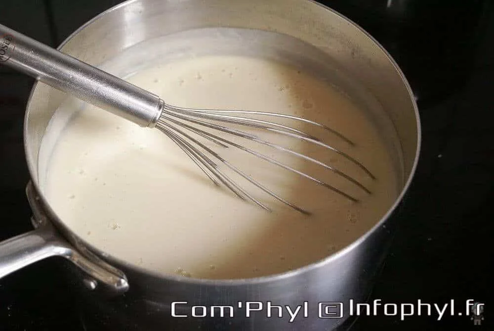 Sauce béchamel crémeuse dans une casserole, idéale pour les gratins et lasagnes, préparée avec du beurre, de la farine et du lait pour une texture lisse et onctueuse.