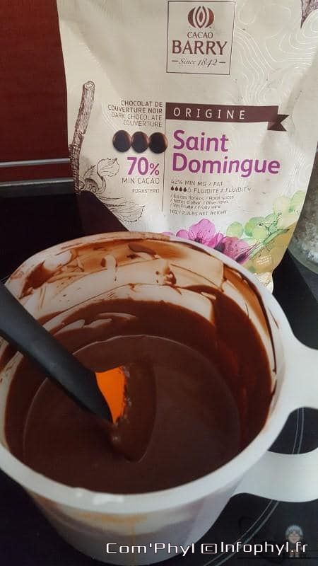 Chocolat de couverture noir Saint Domingue 70% batch, infusion chaude dans une tasse blanche avec cuillère, arrière-plan chocolat Barry, ingrédients et origine authentique, parfait pour recettes gourmandes.
