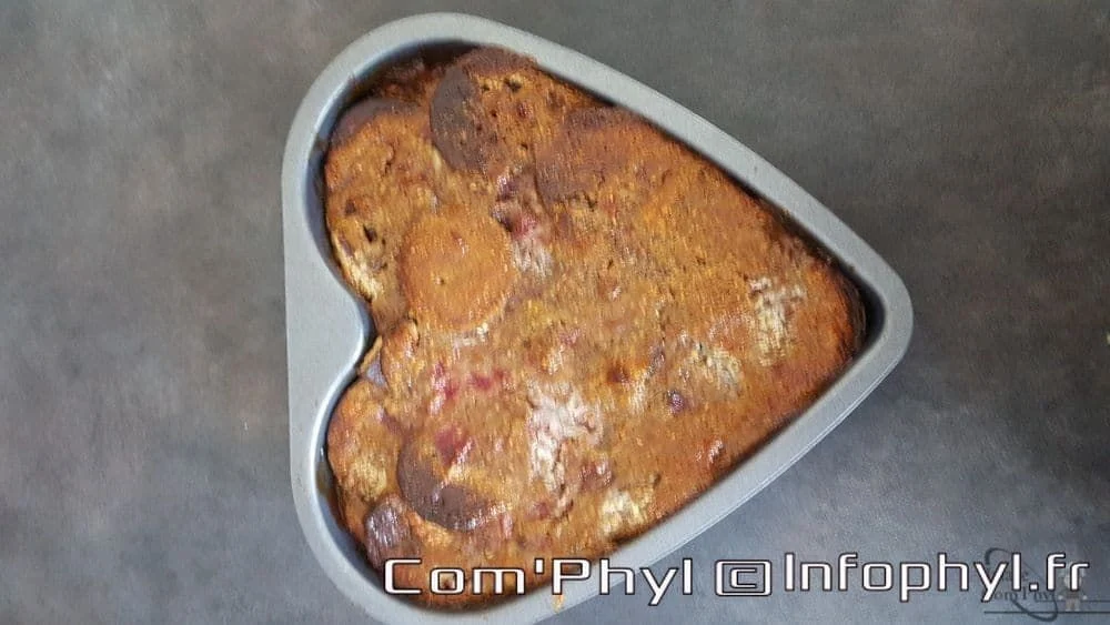 Gâteau moelleux aux fruits rouges, parfait pour un dessert dominical, présenté dans un moule en forme de cœur, décoré de fruits frais et de sucre glace.